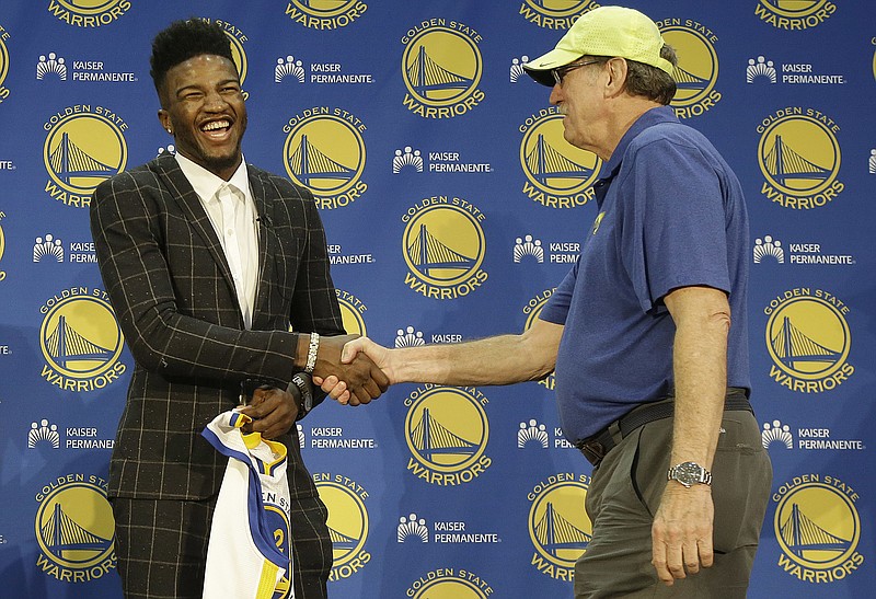 Golden State Warriors NBA basketball draft pick Jordan Bell, left, shakes hands with broadcaster Jim Barnett after at a news conference in Oakland, Calif., Friday, June 23, 2017. 