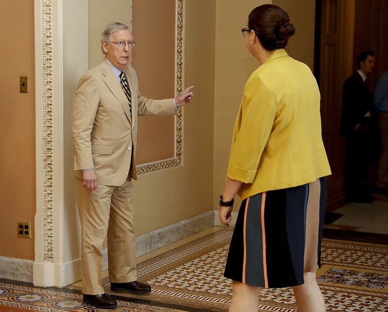 Senate Majority Leader Mitch McConnell of Ky., talks with Secretary for the Majority Laura Dove, as he walks to his office on Capitol Hill in Washington, Monday, June 26, 2017. Senate Republicans unveil a revised health care bill in hopes of securing support from wavering GOP lawmakers, including one who calls the drive to whip his party's bill through the Senate this week "a little offensive." (AP Photo/Carolyn Kaster)