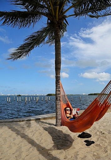 <p>AP</p><p>Kristiina Nurk, 34, enjoys a good book underneath the blue summer-like skies and weather as she vacations in Miami for a second day while on holiday. A new survey from The Associated Press-NORC Center for Public Affairs Research found resting and relaxing is very or extremely important to three-fourths of Americans while on vacation.</p>