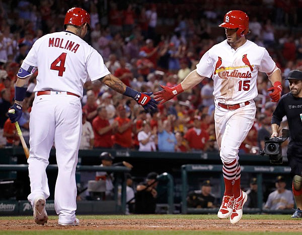 Cardinals left fielder Randal Grichuk is congratulated by teammate Yadier Molina after hitting a solo home run during the sixth inning of Sunday night's game against the Pirates at Busch Stadium in St. Louis.