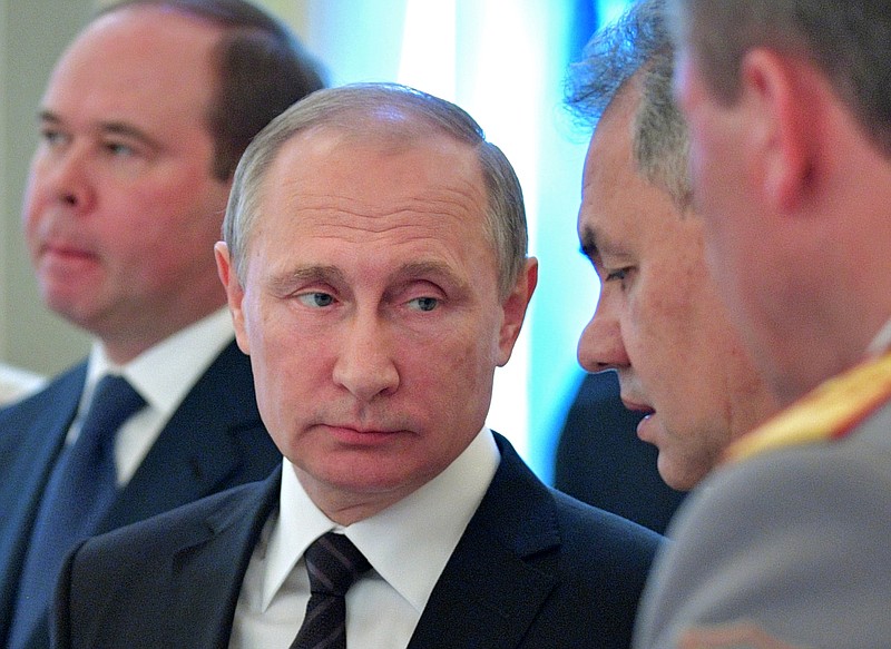 Russian President Vladimir Putin, center, listen to Defence Minister Sergei Shoigu at a meeting with graduates of military and police academies in the Kremlin in Moscow, Russia, Wednesday, June 28, 2017. Putin has pledged to continue efforts to beef up the Russian military and law-enforcement agencies. At left, Chief of presidential administration Anton Vayno. (Alexei Druzhinin/Sputnik, Kremlin Pool Photo via AP)