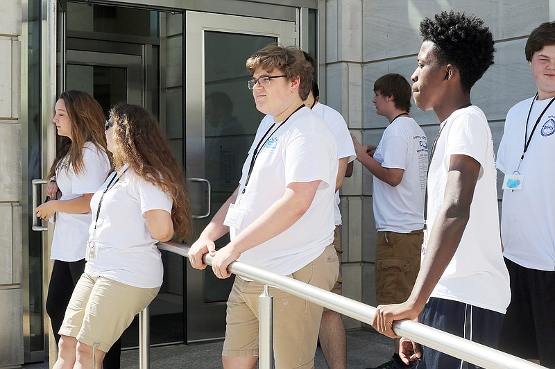 Local students from State Technical College Computer Professions on Demand program relax Tuesday outside the federal courthouse in Jefferson City. The students visited the courthouse while learning about its information technology from Linn State Technical College tour guides.