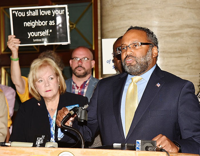 Pat Rowe Kerr, background left, looks on as Missouri NAACP President Nimrod Chapel addresses the media as the NAACP held a press conference in the third floor rotunda Tuesday to voice their opposition to Senate Bill 43. 