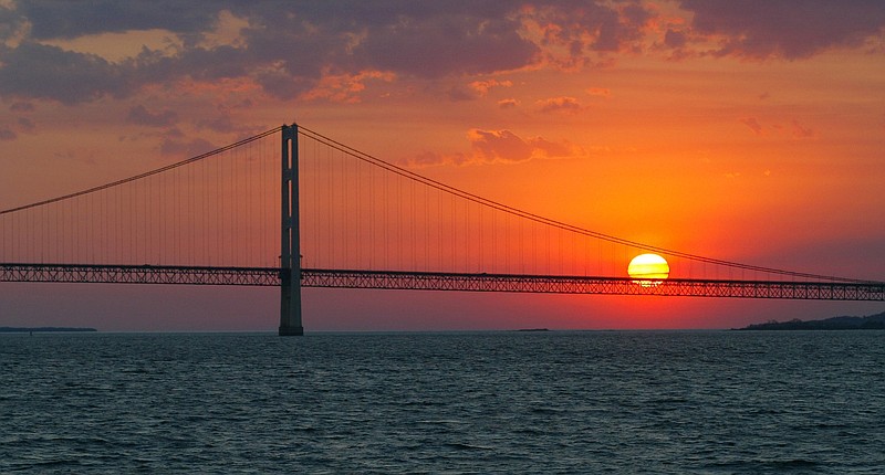 FILE - In this May 31, 2002 file photo, the sun sets over the Mackinac Bridge and the Mackinac Straits as seen from Lake Huron. The bridge is the dividing line between Lake Michigan to the west and Lake Huron to the east. Michigan's attorney general, Republican Bill Schuette, called Thursday, June 29, 2017 for shutting down the nearly 5-mile-long (8-kilometer-long) section of Enbridge Inc.'s Line 5 under the Straits of Mackinac. (AP Photo/Al Goldis, File)