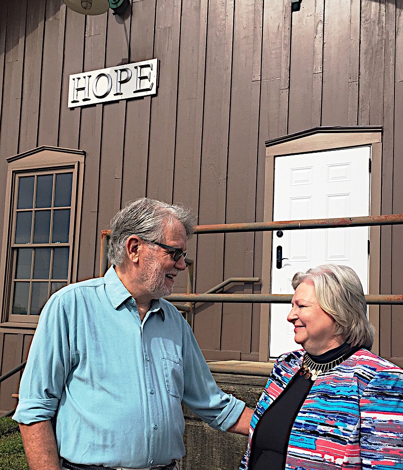 Kim Hollis, right, uses the backdrop of the headquarters of the Southwest Arkansas Arts Council to welcome Hope, Ark., native George S. Smith as the council's new executive director.