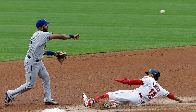 Texas Rangers' Elvis Andrus throws to first base after getting Cleveland Indians' Francisco Lindor out at second base in the first inning of a baseball game, Wednesday, June 28, 2017, in Cleveland. Michael Brantley was safe at first base. 