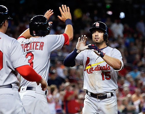 Randal Grichuk high fives teammate Matt Carpenter after hitting a three-run home run in the seventh inning of Thursday's game against the Diamondbacks in Phoenix.