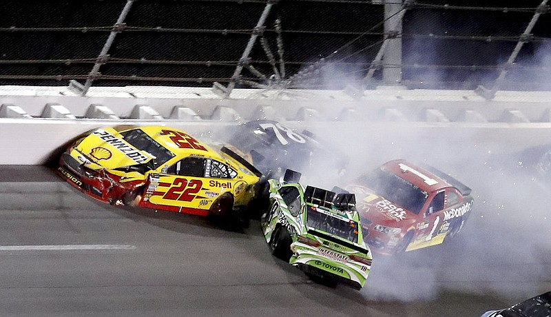 Joey Logano (22), Kyle Busch (18), Jamie McMurray and Martin Truex Jr. (78) get caught up in a wreck in Turn 2 during the NASCAR Cup auto race at Daytona International Speedway, Saturday, July 1, 2017, in Daytona Beach, Fla.