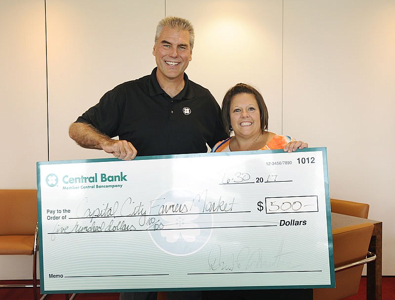 Central Bank President David Minton presents a $500 check to Diana Duncan, a board member of the Capital City Farmer's Market, at Central Bank on Friday, June 30, 2017. The money is going to help fund the farmer's market's initiative for the Double Up Bucks program, which lets low-income shoppers use their SNAP EBT card at the farmers market.