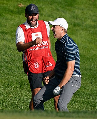 Jordan Spieth celebrates with caddy Michael Greller after sinking a shot from a bunker on the first playoff hole during the final round of the Travelers Championship last month in Cromwell, Conn.