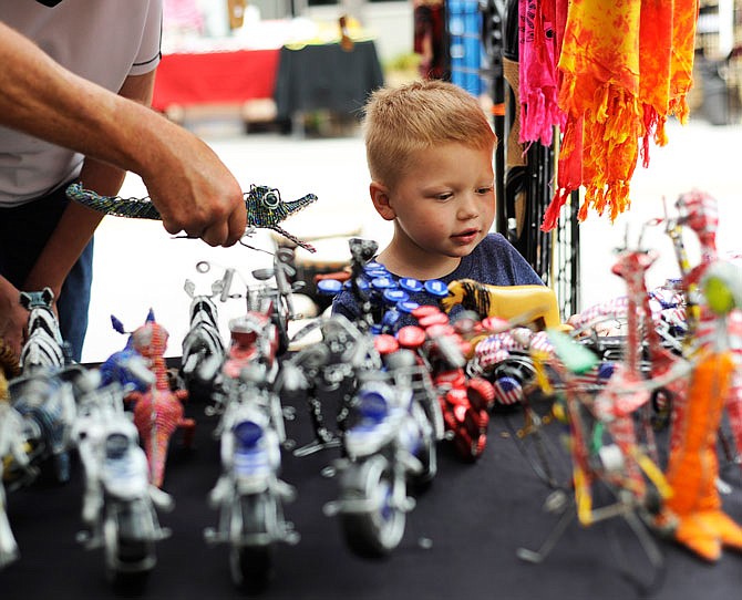 Kolton Walbrecht, 3, looks at the figurines for sale at Uniquk gifts and handicrafts at the Avenue of the Americas Tuesday during the Salute to America festival downtown. Avenue of the Americas was  coordinated by the east and west side business associations.