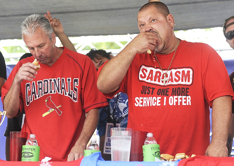 Brandon Clark, also known as "Da Garbage Disposal," right, eats hot dogs Tuesday during the sixth annual hot dog eating contest in downtown Jefferson City. Clark ate 23 hot dogs in the contest.