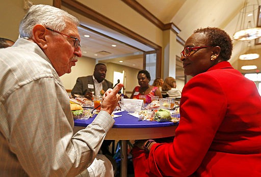 In this June 20, 2017 photo, Roy Vandiver, left, talks with Juanita Pounds at the dining table during the Together We Dine event at Highland Park United Methodist Church in Dallas. The Dallas Morning News reported that more than 150 people of various ethnicities came together as part of the Year of Unity efforts, created in response to the July 7, 2016, ambush in Dallas that left five police officers dead.