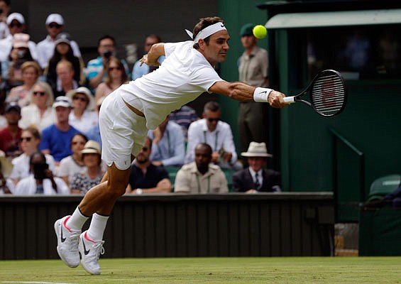 Roger Federer reaches for a return to Alexandr Dolgopolov during their men's' singles match Tuesday at Wimbledon.