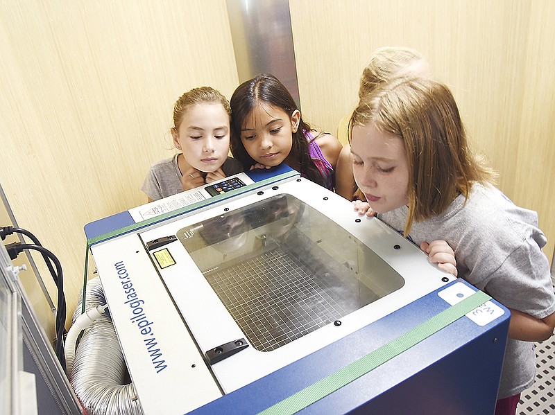 Maty Stockman, Jocelyn Tuua and Jassmin Peek watch a laser printer at work last month aboard the mobile Sinquefield Invention Lab at Cedar Hill Elementary. The Boy Scouts of America Great Rivers Council recently opened a permanent version of the lab at the Lake of the Ozarks Scout Reservation.