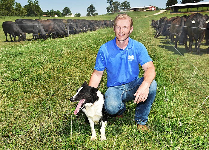 Jameson Morrow and his constant companion, Jonah, pose at one of his Cole County properties on which he raises Black Angus and Gelbvieh cattle. 