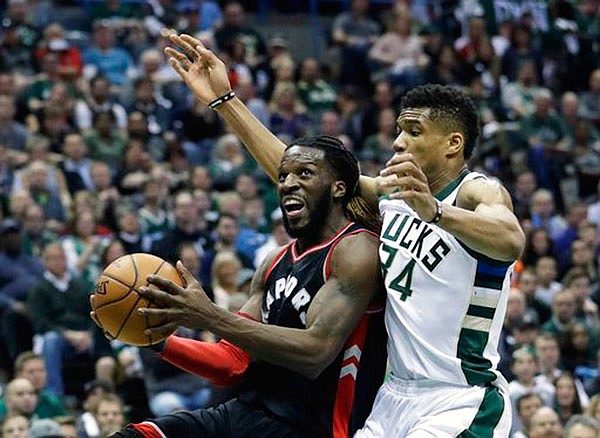 In this April 22 file photo, DeMarre Carroll (left) of the Raptors drives past Giannis Antetokounmpo of the Bucks during a game in the first round of the NBA playoffs in Milwaukee.
