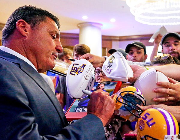 LSU coach Ed Orgeron signs autographs during the Southeastern Conference's annual media gathering Monday in Hoover, Ala.