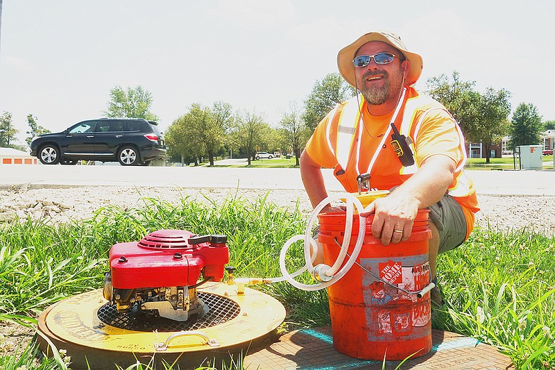 Steve Wilson demonstrates how a motor is used to generate smoke pumped into the sewer system to reveal leaks and cracks. Smoke testing in Holts Summit will continue throughout July.