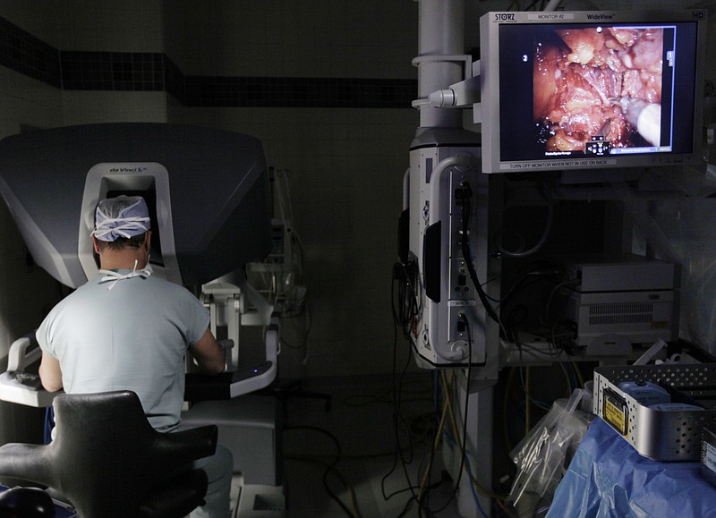 <p>AP</p><p>A surgeon performs a robotic prostatectomy on a patient in Chicago. According to a report released last week, long-term results comparing different approaches for men with cancers confined to the prostate show that after 20 years, death rates were similar for those who had immediate surgery as for those initially assigned to monitoring.</p>