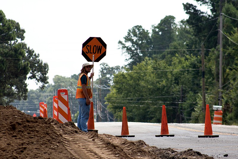 Kolby Kaver directs traffic Wednesday morning on McKnight Road in Texarkana Texas. The city is widening the road to help with traffic flow in the area.