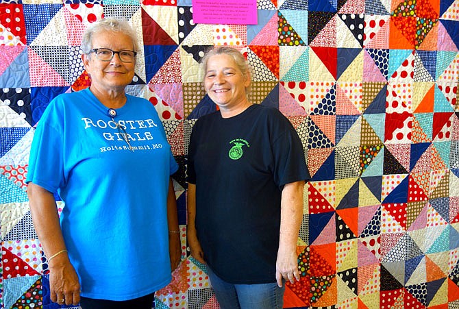 Rooster Creek quilting guild members Ruth Burt, left, and Tonya McDonald helped work on two quilts that willl be raffled off as a fundraiser at the Rooster Creek Company Quilt Show. "We had an assembly line going," McDonald said. "Everyone pitched in." Funds will go to train a service dog for Sophia Six, a girl with epilepsy.