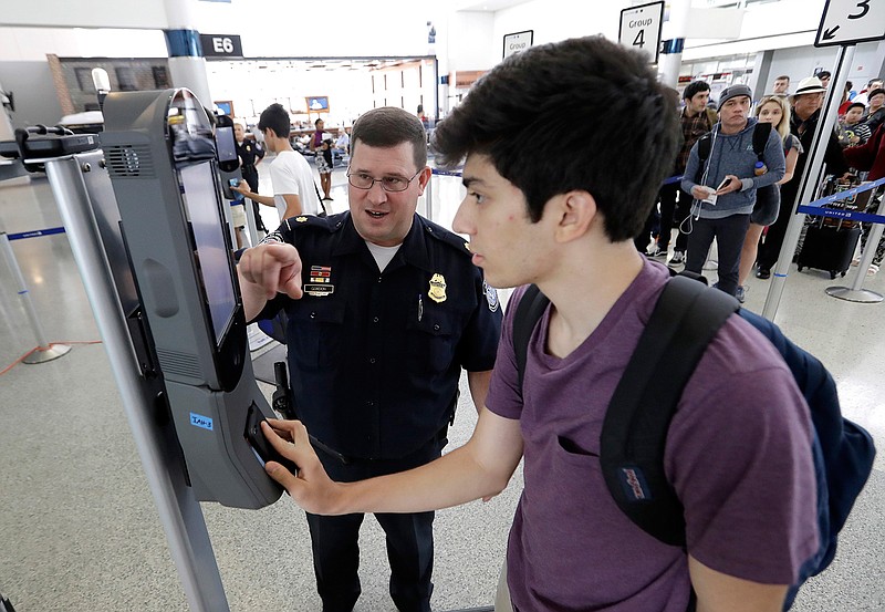 U.S. Customs and Border Protection supervisor Erik Gordon, left, helps passenger Ronan Pabhye navigate one of the new facial recognition kiosks at a United Airlines gate before boarding a flight to Tokyo, Wednesday, July 12, 2017, at George Bush Intercontinental Airport, in Houston. The Trump administration intends to require that American citizens boarding international flights submit to face scans, something Congress has not explicitly approved and privacy advocates consider an ill-advised step toward a surveillance state. 