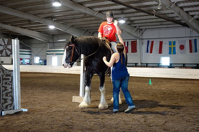 It's a job well done as Illinois rider Olivia McDermott, 12, high-fives Liz Haben, western-discipline professor at William Woods University. During training on the obstacle course Wednesday, McDermott took her 19-hand Clydesdale, Bilbo, through the gate, which opened and shut with a rope. They also successfully managed manuevers inside a 6-by-8-foot "box," a huge feat for the horse. McDermott said she's never ridden him before.