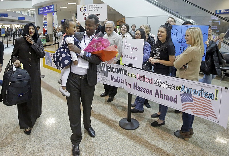 FILE - This Feb. 10, 2017, file photo, Abdisellam Hassen Ahmed, a Somali refugee who had been stuck in limbo after President Donald Trump temporarily banned refugee entries, walks with his wife Nimo Hashi, and his 2-year-old daughter, Taslim, after arriving at Salt Lake City International Airport, in Salt Lake City. Ahmed meet his 2-year-old daughter, Taslim, for the first time. A federal judge in Hawaii further weakened the already-diluted travel ban Thursday, July 13, 2017, by vastly expanding the list of U.S. family relationships that visitors from six Muslim-majority countries can use to get into the country. (AP Photo/Rick Bowmer, File)
