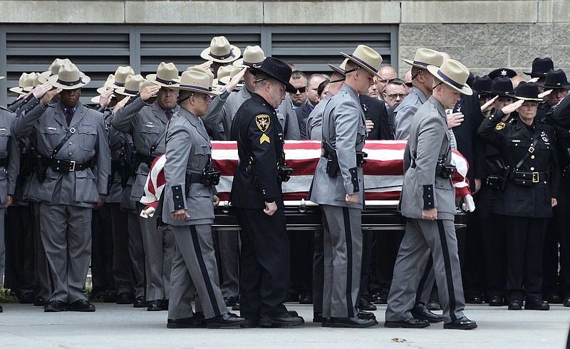 The casket of slain New York state trooper, Joel Davis, is carried out of the Magrath Sports Complex at Fort Drum, N.Y., by law enforcement personnel, during Davis's funeral service, Saturday, July 15, 2017. Trooper Davis, 36, was fatally shot July 9, while responding to reports of gunfire on a couple's property in the town of Theresa, N.Y. Police say a Fort Drum soldier, Staff Sgt. Justin Walters, fatally shot his 27-year-old wife before shooting Davis.  (AP Photo/Heather Ainsworth)