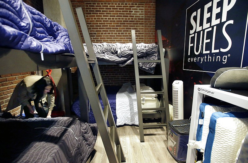 In this Wednesday, May 31, 2017, photo, Zineb Curran, left, Boston Red Sox senior director of corporate communications, arranges bedding in a nap station near the team's clubhouse at Fenway Park in Boston. Day-night doubleheaders. Cross-country travel. Rain delays and extra innings. A baseball season can play havoc with a player's sleep schedule, but the Red Sox think they have one answer with a room for napping.