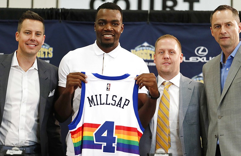 In this July 13, 2017, file photo, Denver Nuggets new NBA basketball forward Paul Millsap, second from left, holds up his new jersey as Josh Kroenke, team president and governor, left, Tim Connelly, president of basketball operations and Arturas Karnisovas, general manager of the Nuggets, join in for a photograph during Millsap's introduction to the media at a news conference in Denver. 