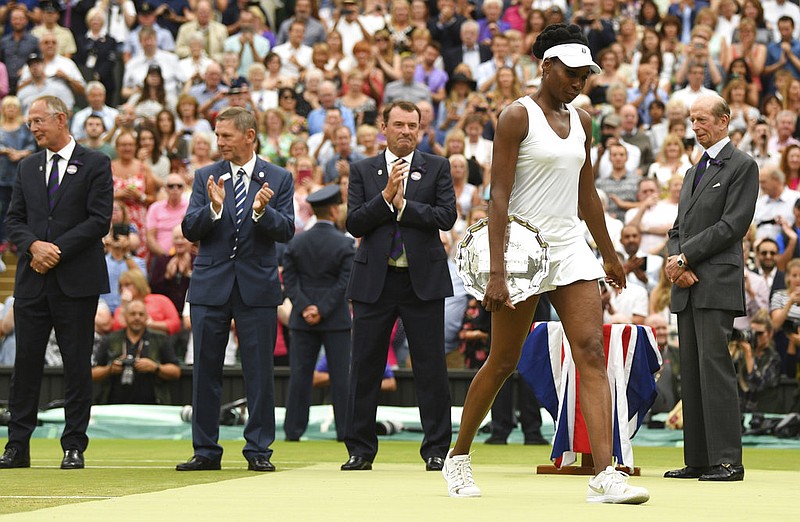 Venus Williams of the United States holds the runners-up plate after losing to Spain's Garbine Muguruza in the Women's Singles final match on day twelve at the Wimbledon Tennis Championships in London Saturday, July 15, 2017.