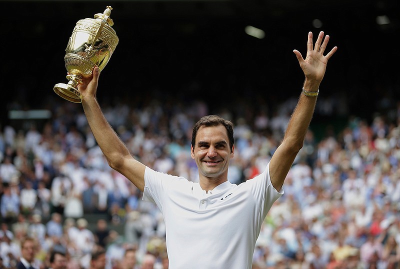 Switzerland's Roger Federer celebrates with the trophy after beating Croatia's Marin Cilic in the Men's Singles final match on day thirteen at the Wimbledon Tennis Championships in London Sunday, July 16, 2017. 