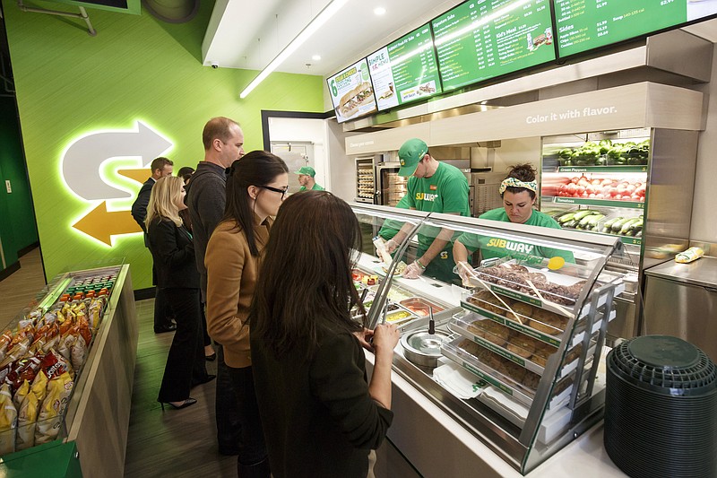 This January 2017 photo provided by Subway shows the interior of a remodeled Subway store in Knoxville, Tenn. Subway is looking to update the look of its stores as the chain's U.S. sales have been declining. The company says the redesign, which includes a brighter atmosphere, displays of vegetables behind the counter and ordering tablets, is the first major revamp since the early 2000s. (Chris Radcliffe/Subway via AP)