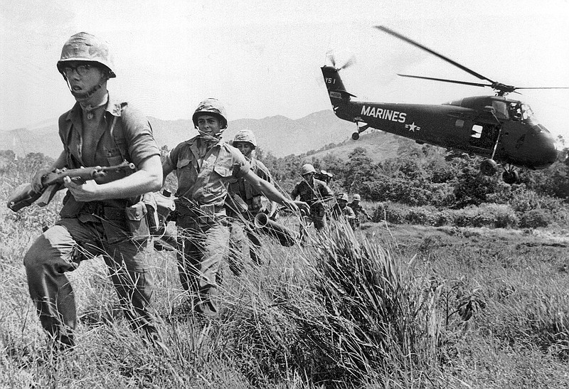 In this April 28, 1965 file photo, U.S. Marine infantry stream into a suspected Viet Cong village near Da Nang in Vietnam during the Vietnamese war. Filmmaker Ken Burns said he hopes his 10-part documentary about the War, which begins Sept. 17, 2017 on PBS, could serve as sort of a vaccine against some problems that took root during the conflict, such as a lack of civil discourse in America.