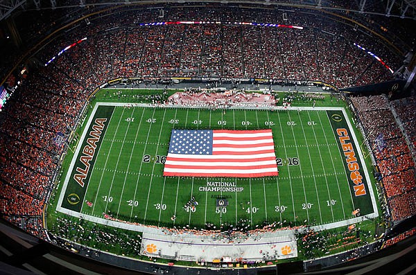 In this Jan. 11, 2016, file photo, an American flag is seen on the field during the national anthem before the college football playoff championship game between Clemson and Alabama, in Glendale, Ariz. The ACC, led by Clemson, believes it has caught up with the SEC, topped by Alabama.