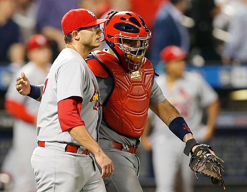Cardinals relief pitcher Brett Cecil and catcher Yadier Molina prepare to celebrate with their teammates after Cecil closed out the Cardinals' 6-3 victory Monday night against the Mets in New York.