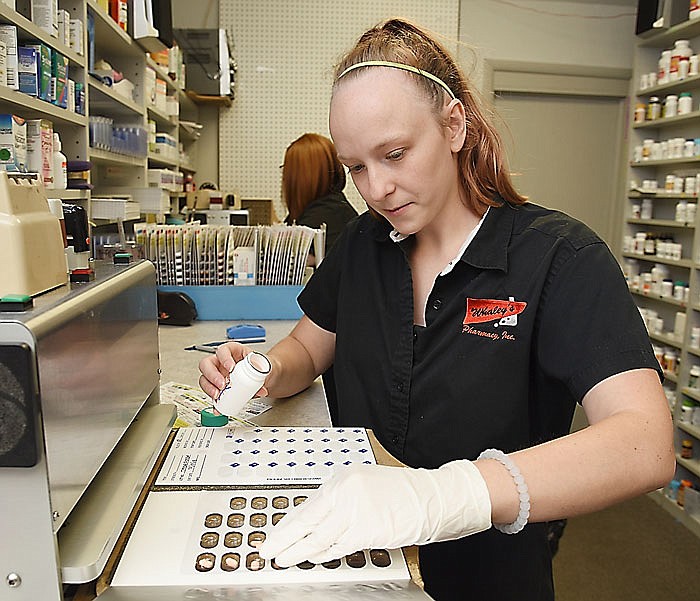 Krystal Binkley fills prescription bubble packs at Whaley's Pro Care Services. Binkley is a  pharmacy technician and fills prescriptions for dispensing in nursing homes.