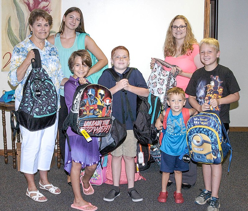 A number of backpacks, each containing needed items for foster children, donated by members of the congregation of California's St. Paul's Lutheran Church, are shown before being picked up by Sue Engelage, back row at the right, the Program Coordinator of Central Missouri Foster Care and Adoption Association (CMFCAA). In the photo, from left, are Beth Jungmeyer, Caydence Cooper, Alexis Diehl, Jack Lake, Engelage, Lawson Hays and Landon Hays.