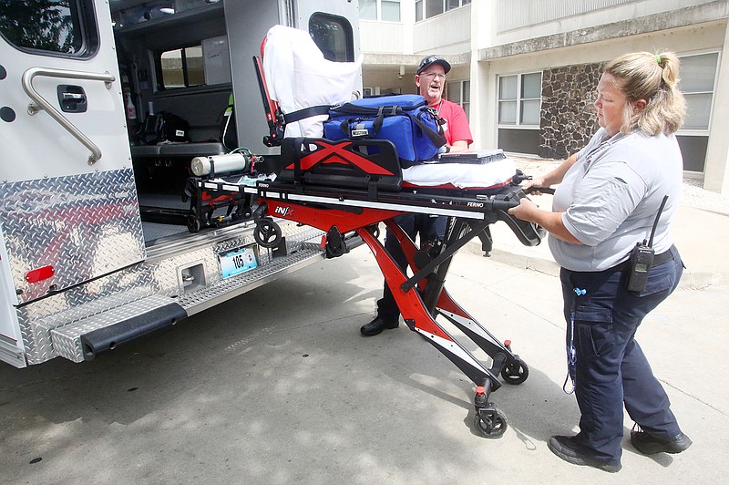 Malinda Fast, right, and Joe Piskulic put an unused stretcher back in an ambulance after responding to a call Tuesday at Dulle and Hamilton Towers. The emergency response technicians did not need to transport after they stabilized a patient with diabetes.