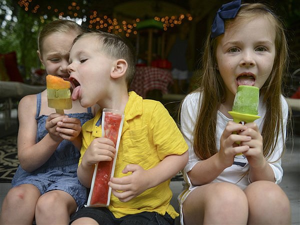 Enjoying homemade popsicles on Thursday, July 6, 2017, are, from left, siblings Mae, Caleb and Autumn Waters. 