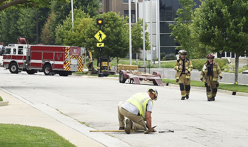 An Ameren Missouri employee pulls up a manhole cover as the company and the Jefferson City Fire Department respond to a gas line break in the 100 block of East Miller Street on Wednesday, July 19, 2017. A crew was digging for an underground line and hit the natural gas line shortly before 1:30 p.m.