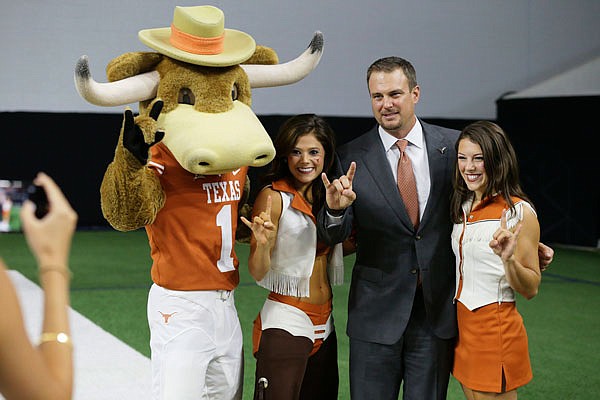Texas head coach Tom Herman (second from right) poses for photos Tuesday after speaking to reporters during the Big 12 football media day in Frisco, Texas.
