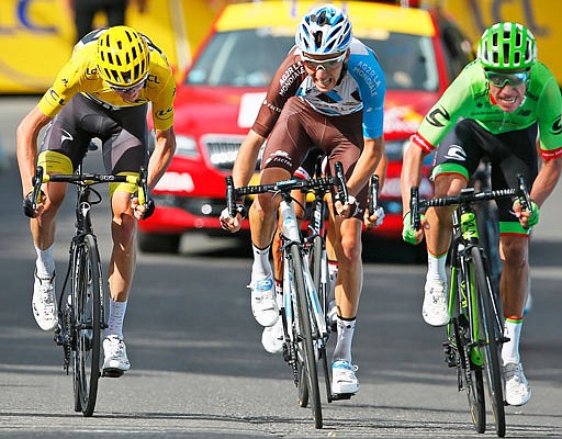 Chris Froome, wearing the overall leader's yellow jersey, Romain Bardet (center) and Rigoberto Uran (right) sprint towards the finish line of the seventeenth stage of the Tour de France on Wednesday.