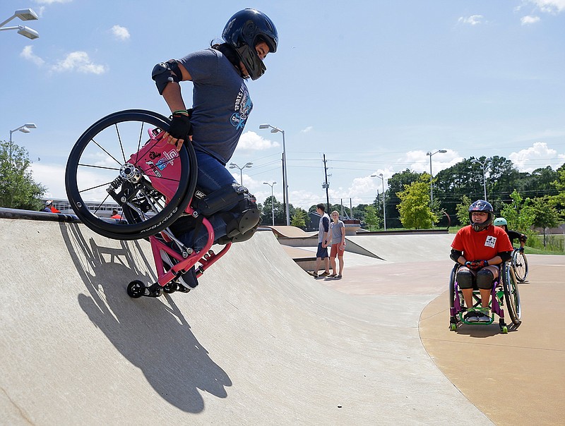 In this Sunday, July 16, 2017 photo, Leslie Marroquin, 16, of Houston makes a maneuver down a ramp during a wheelchair motocross event at North Houston Skate Park in Houston. Bailey, 34, has cerebral palsy. But she has discovered the world of so-called "adaptive athletics," learning to let the wheelchair become a tool to participate in sports. Marroquin has been using a wheelchair for six months. Her legs are paralyzed, but her mother had wanted to find activities still available to her. She connected with Bailey online.