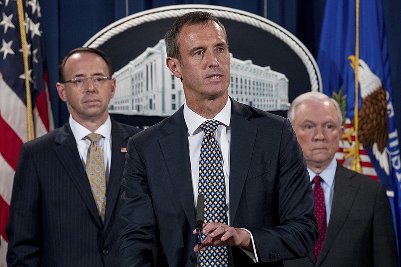 Europol Executive Director Robert Mark Wainwright, center, accompanied by Attorney General Jeff Sessions, right, and accompanied by Deputy Attorney General Rod Rosenstein, left, speaks at a news conference to announce an international cybercrime enforcement action at the Department of Justice, Thursday, July 20, 2017, in Washington. (AP Photo/Andrew Harnik)