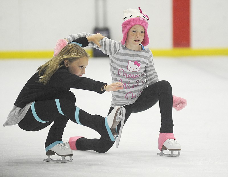 Abigail Bruce and Jessie Johnson skate to the tune of "Walking on Sunshine." The two girls perform in a group routine with other girls close to their age. 