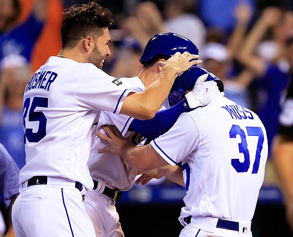 Royals designated hitter Brandon Moss (37) is congratulated by Eric Hosmer (35) after scoring the winning run during the ninth inning of Wednesday night's game against the Tigers at Kauffman Stadium.