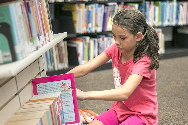 In this July 2017 file photo, Paige Bremer, 9, searches for the perfect book at the Texarkana Public Library.